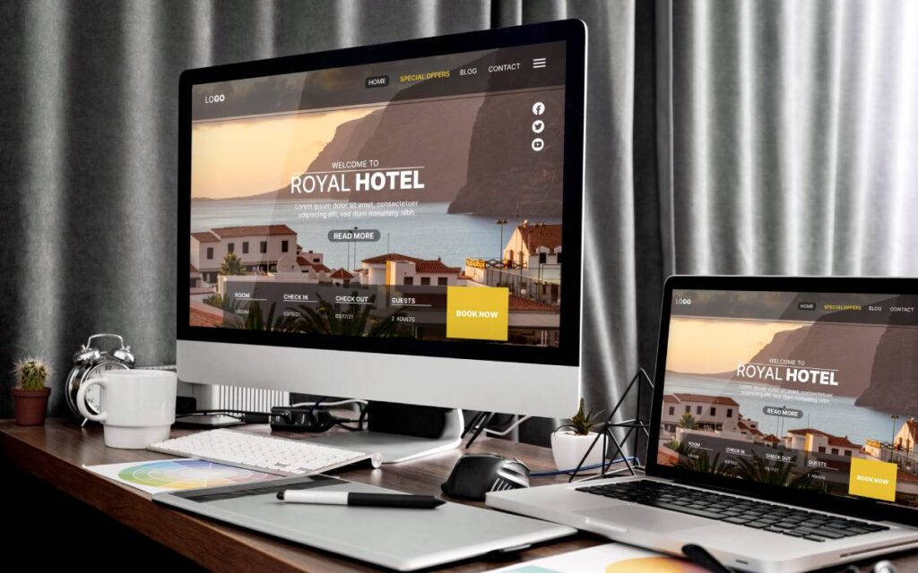 Guia Definitivo 2024: Como Criar um Site Profissional do Zero 2 Desenvolvimento de site profissional exibido em um monitor e um laptop com o design do Royal Hotel.