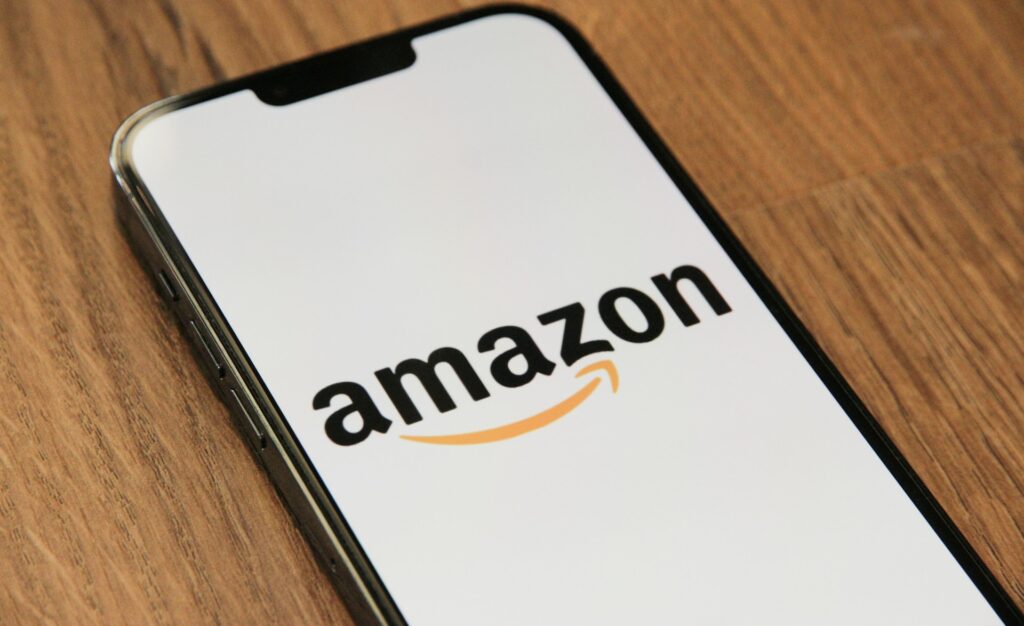 Anatel vence Amazon e reforça fiscalização sobre celulares irregulares 1 Logotipo da Amazon ao centro com caixas de entrega ao redor; representa o novo Amazon Mercado no Brasil