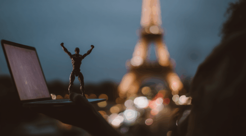 Ilustração de um laptop aberto com código e um robô pequeno sobre a mesa, simbolizando Devstral