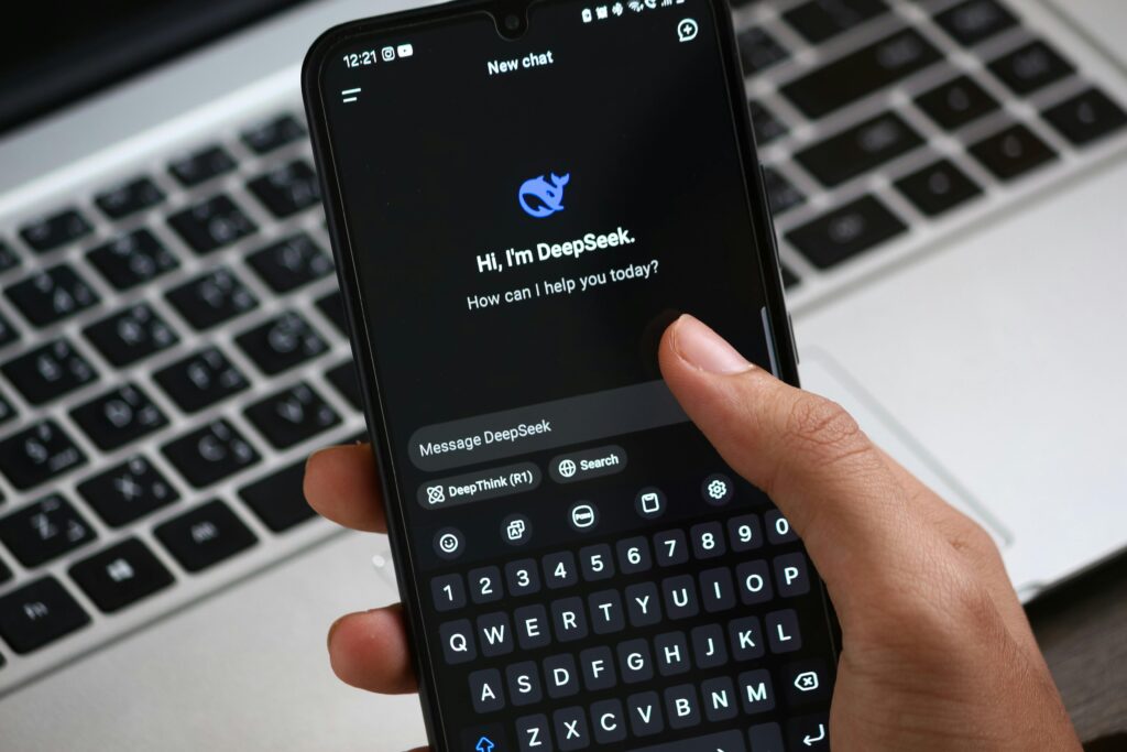 DeepSeek R1: Atualização com Censura Reforçada 2 Pessoa interagindo com o aplicativo de bate-papo DeepSeek AI no smartphone, com foco em inovação digital e comunicação.