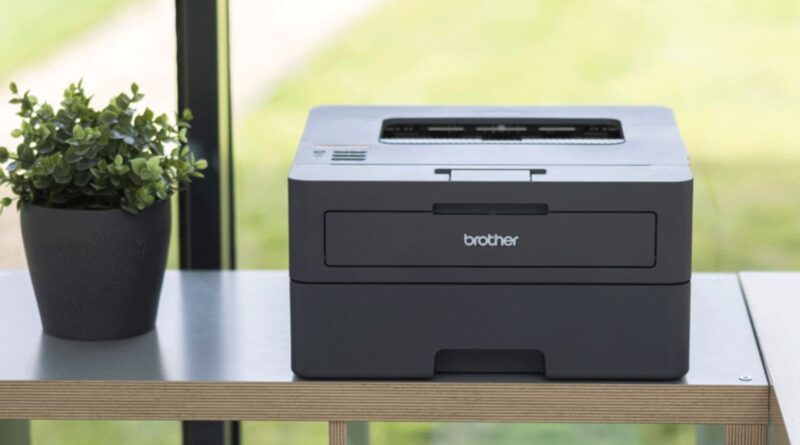 Impressora Brother sobre superfície de madeira, destacando design e uso corporativo e residencial. Exposta em ambiente bem iluminado. Falha de segurança impressoras Brother