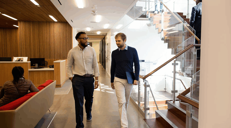 O gerente de vendas se reúne informalmente enquanto caminha com um profissional de TI para discutir a integração de software.