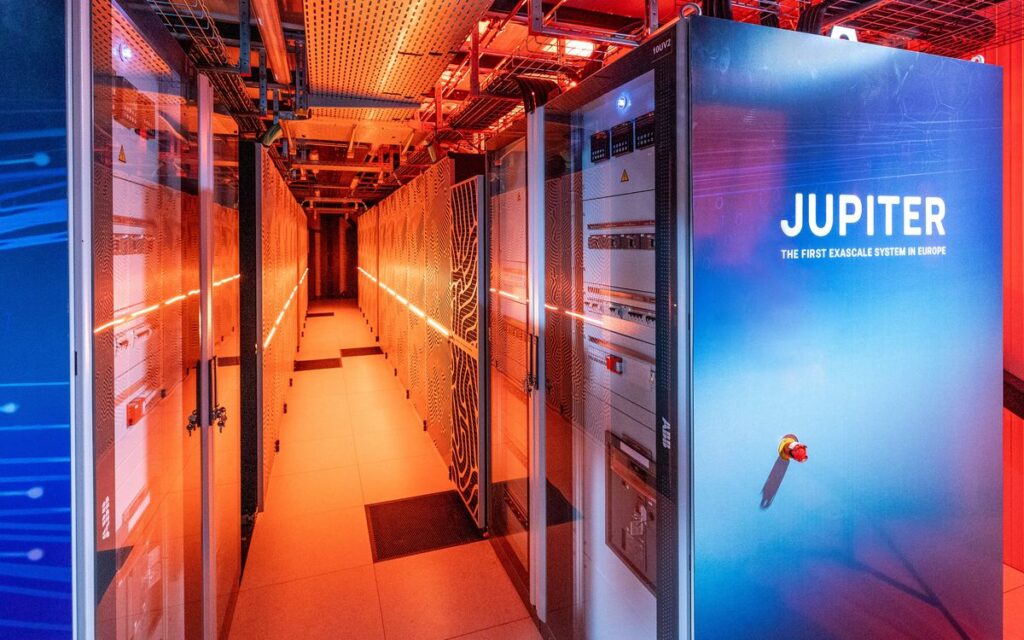 Gabinete azul do supercomputador exascale JUPITER na sala de servidores, destacando refrigeração com luz vermelha