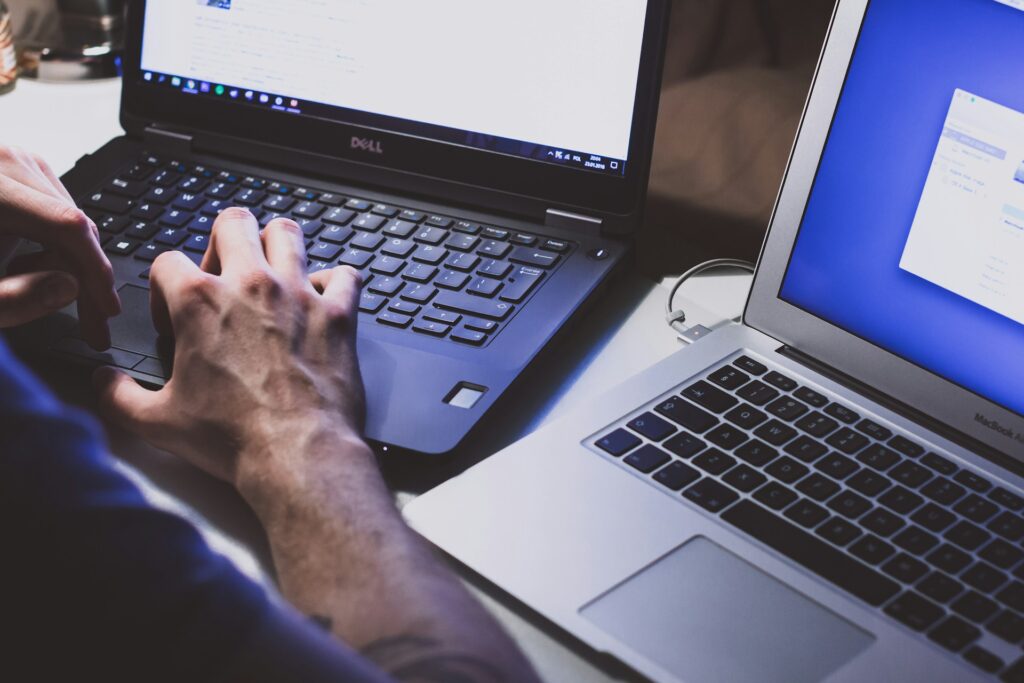 Vazamento de 16 bilhões de senhas: entenda o impacto no Brasil 1 imagem de pessoa digitando com dois laptops