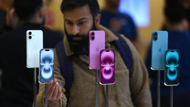 Homem observa iPhones em loja mostrando concorrência tecnológica, possível alvo das novas intervenções britânicas sobre Apple e Google no Reino Unido