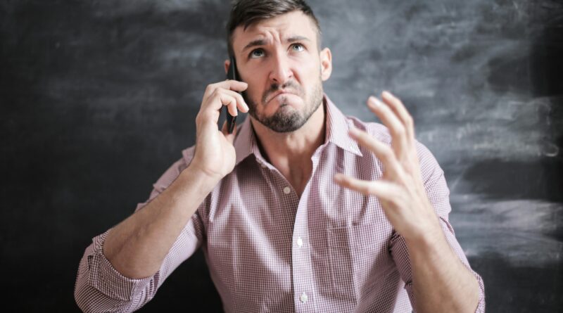 Consumidor frustrado em ligação para atendimento ao cliente, ilustrando a queda na qualidade do serviço