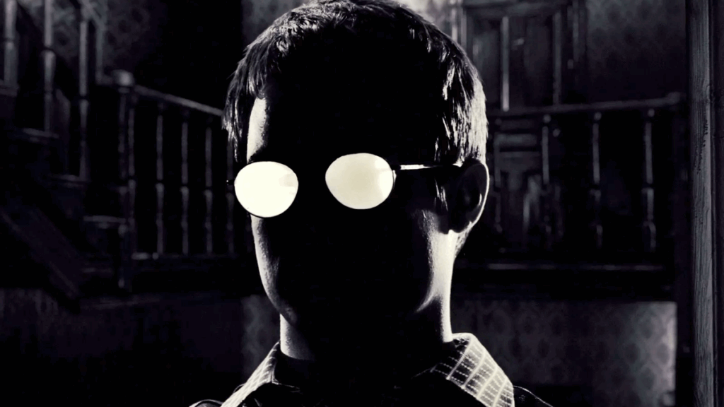 6 HQs dos anos 1990 que viraram filmes marcantes no cinema 7 Miramax Films - Cena emblemática de Sin City representa a estética noir que marcou a transição das HQs para o cinema nos anos 1990, destacando a influência visual dos quadrinhos no cinema.