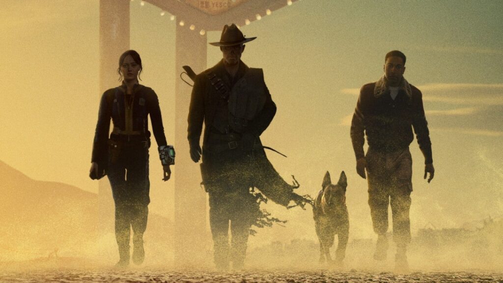 Pôster oficial de Fallout 2 com Lucy MacLean, The Ghoul, Maximus e Dogmeat às portas de New Vegas. Destaque para a atmosfera desértica e ameaçadora do novo cenário.