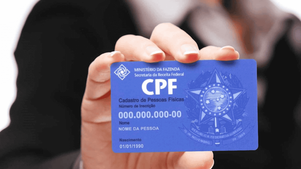 Pessoa segura um cartão de CPF; atenção a pedidos de regularização