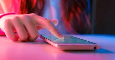 Mão usando smartphone para Desativar a reprodução automática nas redes sociais