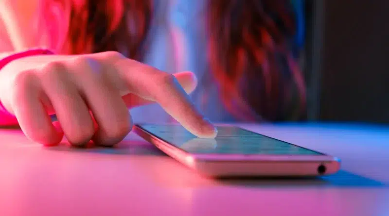 Mão usando smartphone para Desativar a reprodução automática nas redes sociais