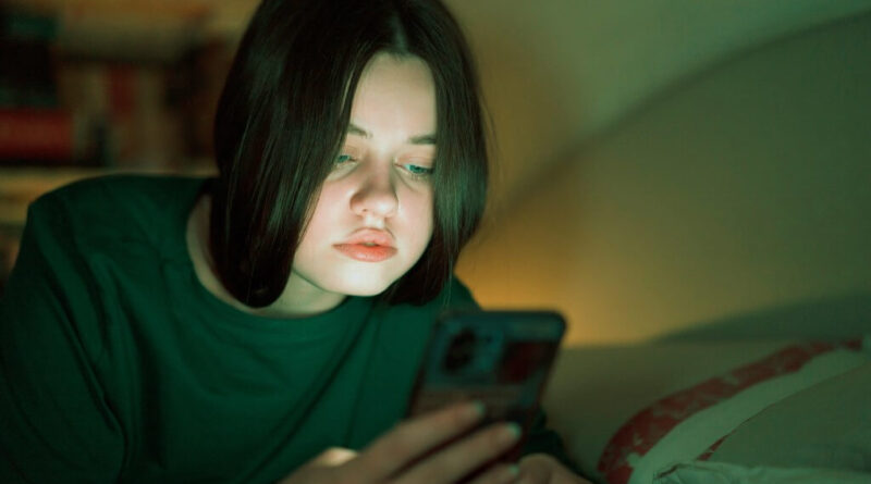 Adolescente olha para o celular; OpenAI prepara controles parentais no ChatGPT e roteamento ao GPT-5 para aumentar a segurança em conversas sensíveis