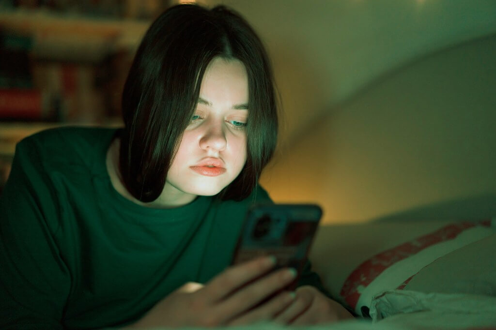 OpenAI: conversas sensíveis no GPT‑5 e controles parentais 1 Adolescente olha para o celular; OpenAI prepara controles parentais no ChatGPT e roteamento ao GPT-5 para aumentar a segurança em conversas sensíveis