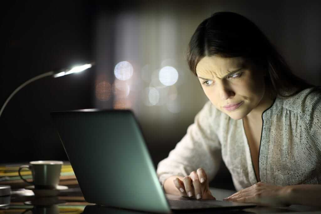 Pessoa desconfiada analisa um notebook com suposta restituição da nota