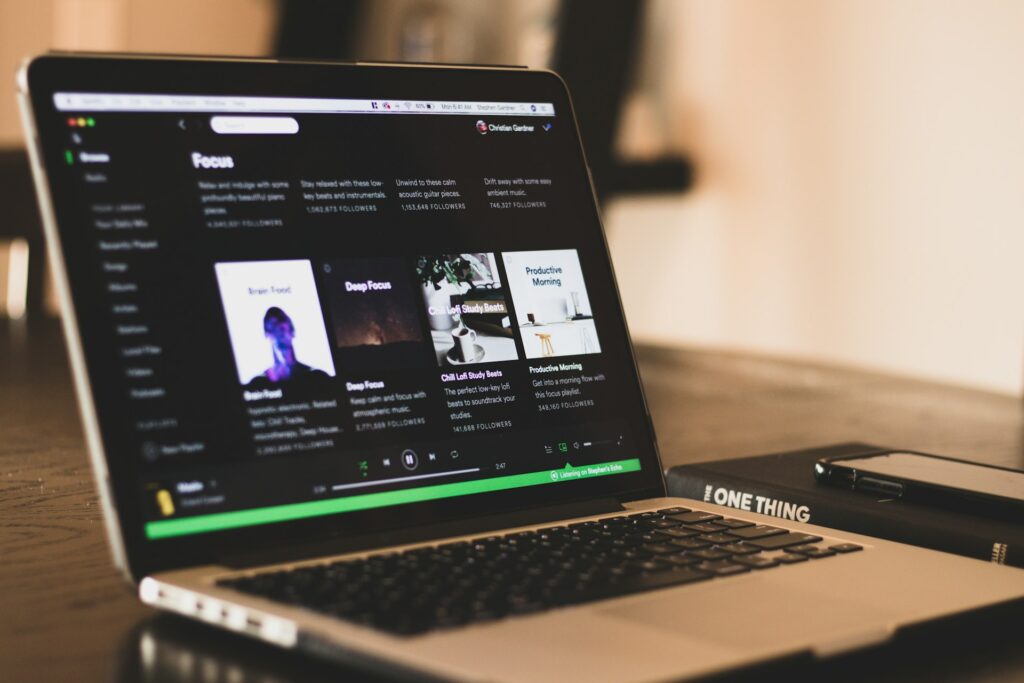 Como baixar músicas do Spotify em MP3 com qualidade 6 Ilustração de reprodução de música em laptop e fones; baixar músicas do Spotify em MP3 para ouvir offline