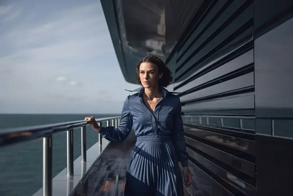 A Mulher da Cabine 10 na Netflix: thriller psicológico 7 Keira Knightley como Lo Blacklock observando o convés envidraçado do iate