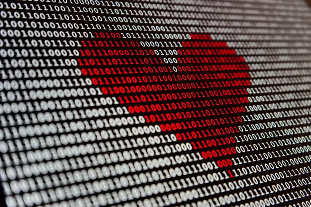 Imagem com código binário formando um coração vermelho, representando o vazamento de dados de apps de namoro.