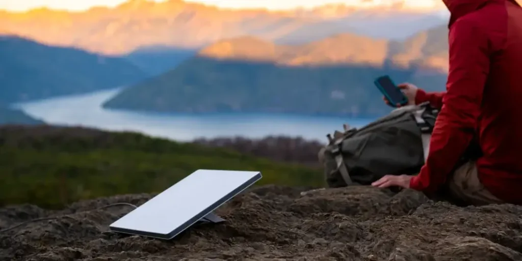 Starlink libera internet gratuita na Venezuela após operação dos EUA 3 Antena da Starlink instalada ao ar livre ao lado de um usuário com smartphone