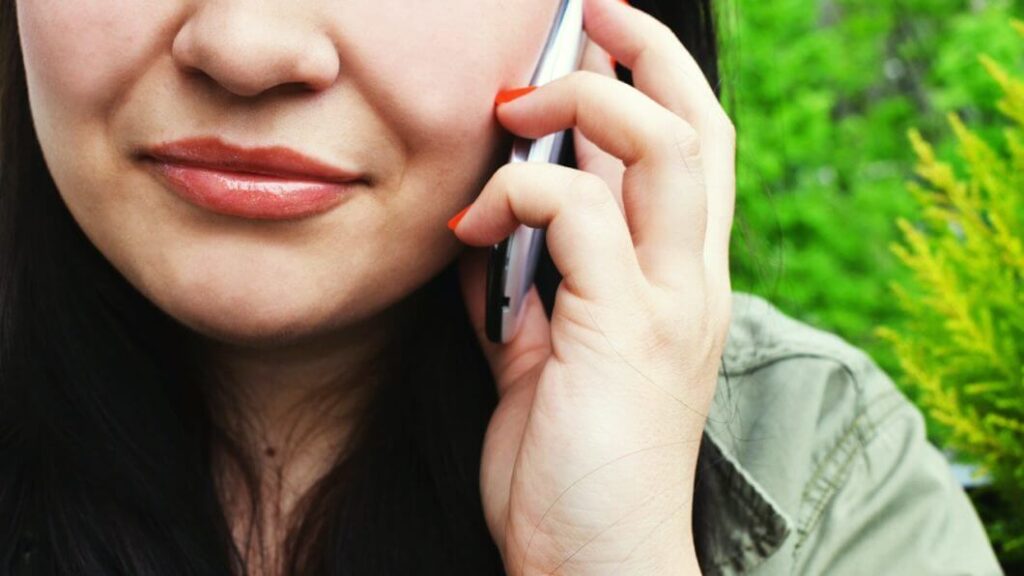 Mulher em ligação no celular, representando troca de operadora