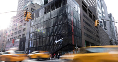 Loja da Nike em Nova York com a marca visível na fachada e carros passando na rua